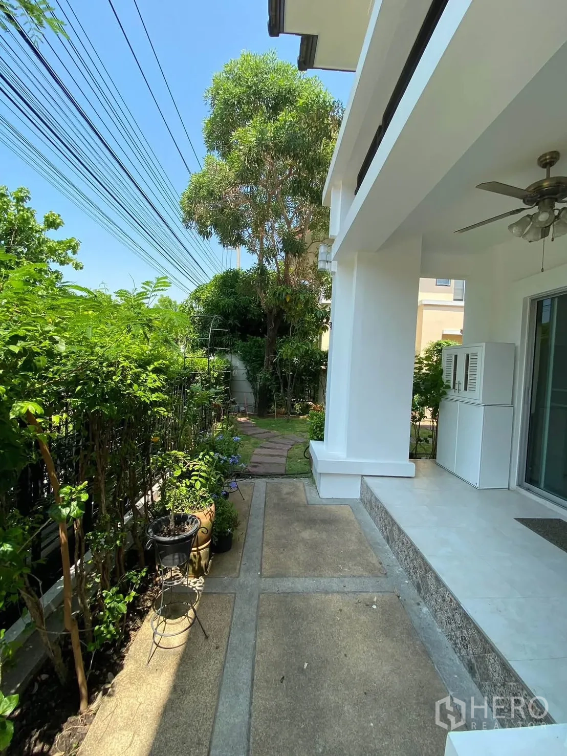 Detached House for rent in Mueang Samut Prakan, Samut Prakan - Shaded side patio and walkway bordered by plants and hedges.