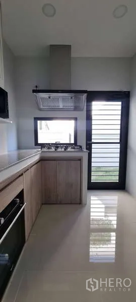 บ้าน ให้เช่าในLat Krabang, Bangkok - มุมครัวเชื่อมประตูหลังบ้าน มีหน้าต่างระบายอากาศและพื้นเงางาม