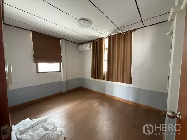 บ้าน ให้เช่าในPhra Khanong, Bangkok - ห้องนอนสว่าง พื้นไม้ แอร์ และหน้าต่างสองบานพร้อมผ้าม่าน.