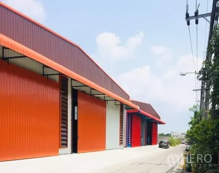 货栈 出租在Khan Na Yao, Bangkok - 曼谷坤那耀区一排橙色钢结构仓库，配大卷闸门与临街通道。