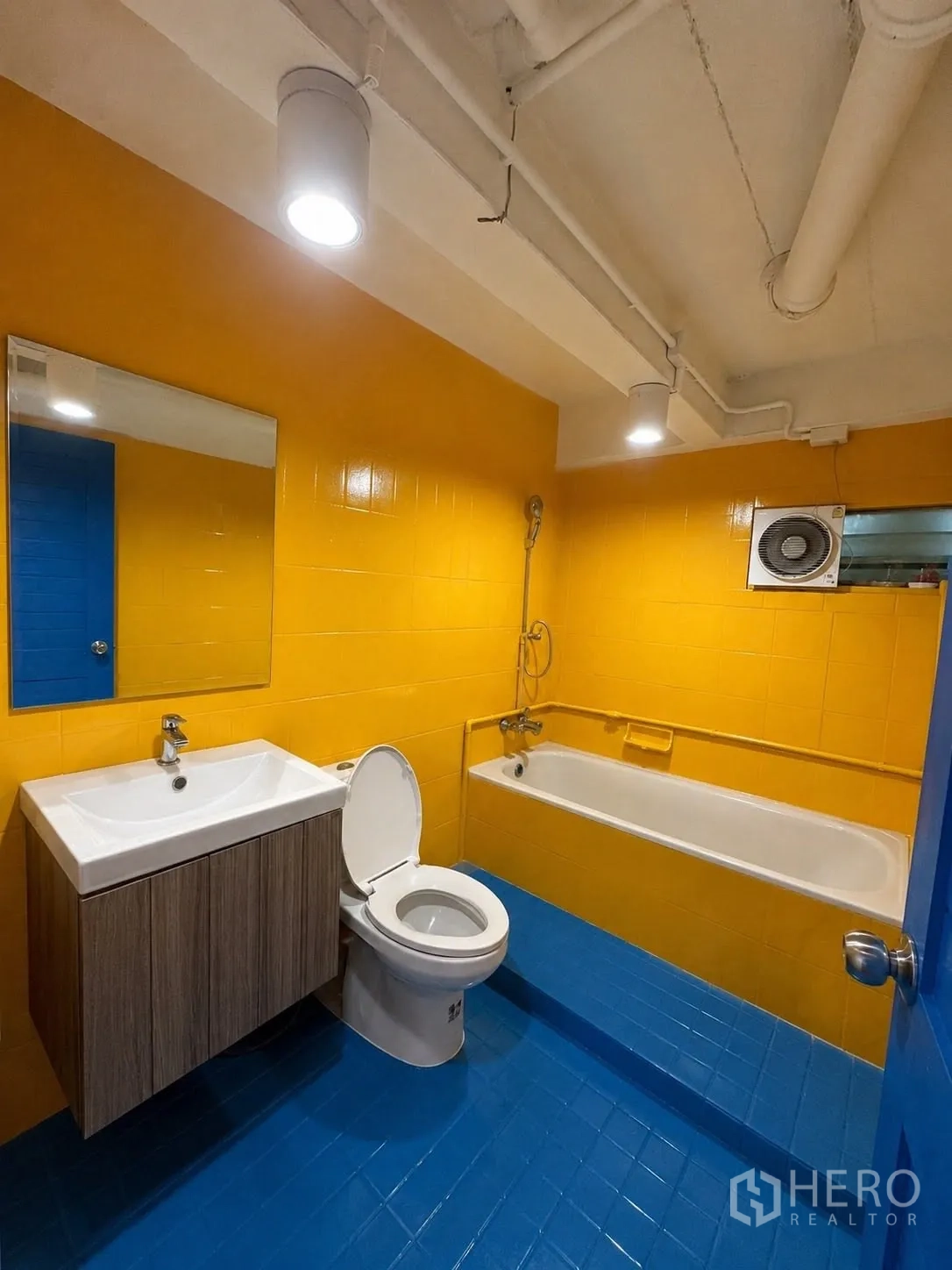 Office Space for rent in Phaya Thai, Bangkok - Colorful bathroom with yellow walls, blue floor and bathtub.