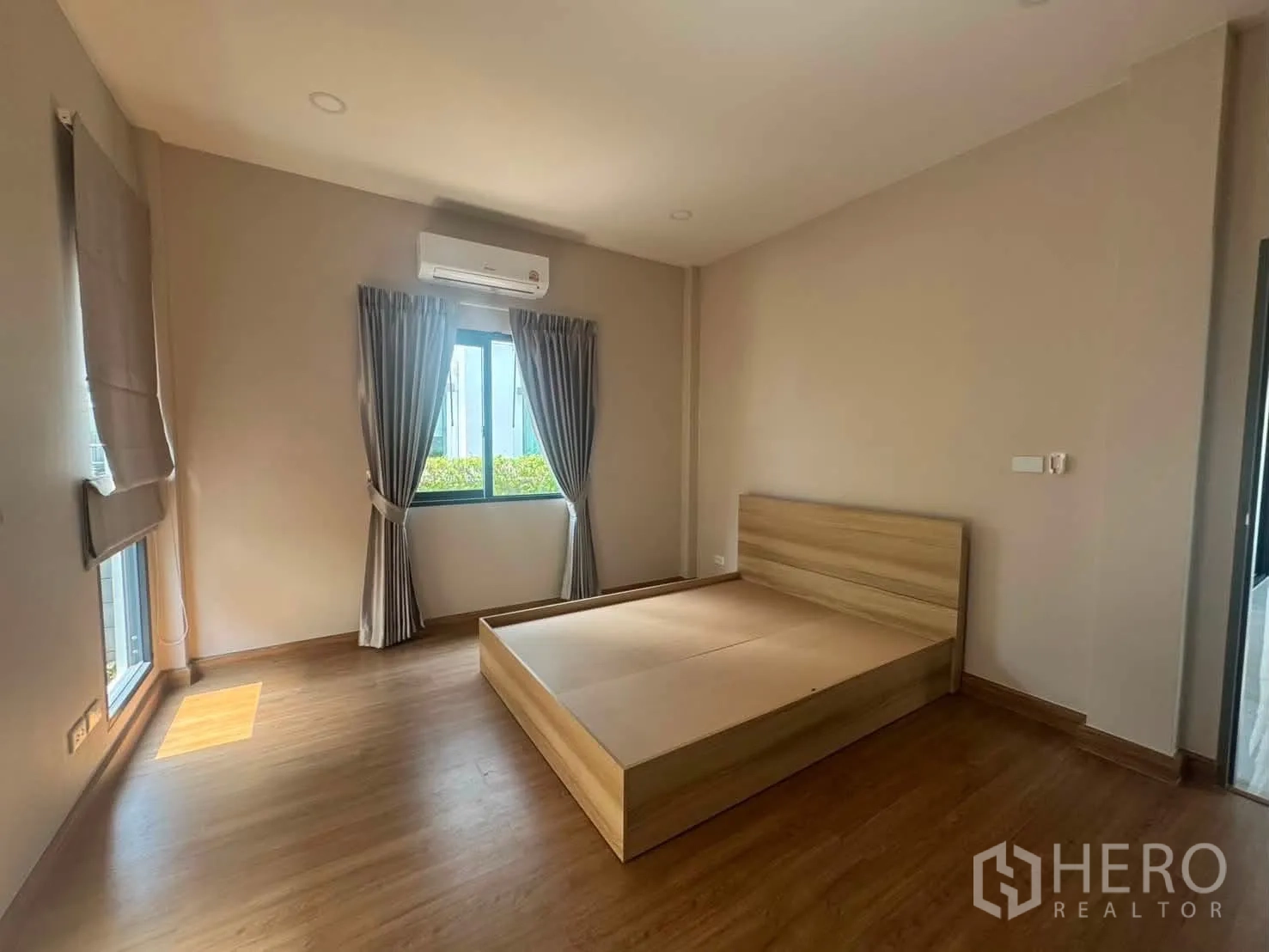 บ้านเดี่ยว for rent or sale in Prawet, Bangkok - ห้องนอนสว่างพื้นลายไม้ เตียงไม้ ผ้าม่าน และเครื่องปรับอากาศ