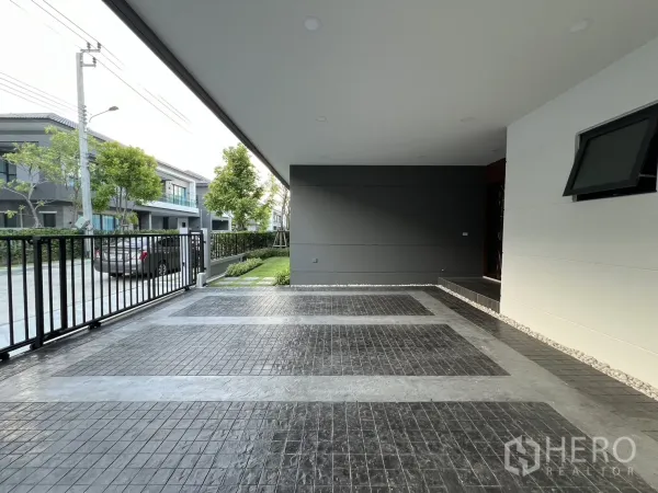 Detached House for rent or sale in Bang Phli, Samut Prakan - Covered carport with patterned tile floor and sliding metal gate, space for multiple cars.