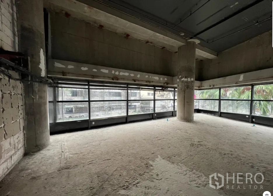 พื้นที่ขายปลีก ให้เช่า - มุมพื้นที่ค้าปลีกมีกระจกเต็มผนัง พื้นที่ดิบพร้อมเสาโครงสร้าง