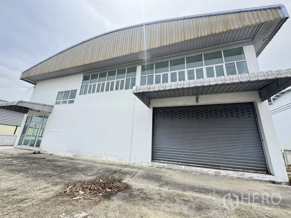 คลังสินค้า ขายในMueang Samut Prakan, Samut Prakan - มุมมองด้านหน้าโกดังเดี่ยว ประตูม้วนขนาดใหญ่และช่องแสงเหนือ บางปู