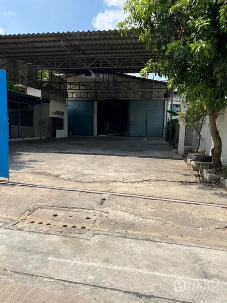 คลังสินค้า ให้เช่าในKhlong Toei, Bangkok - ทางเข้าโกดังพร้อมถนนคอนกรีตกว้างและหลังคาเมทัลชีทสูง