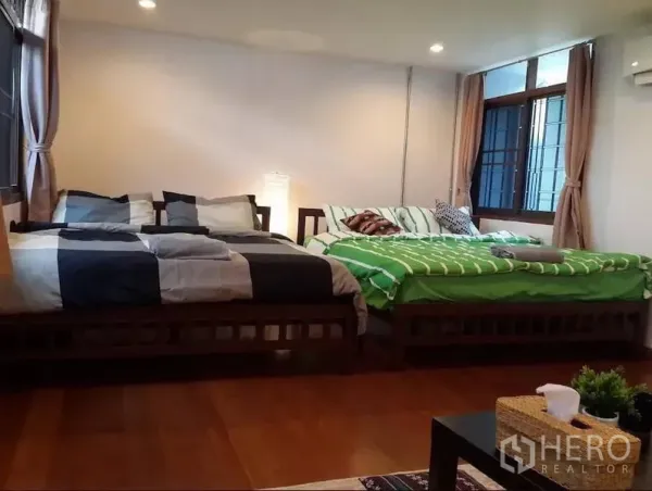 ทาวน์เฮาส์ ให้เช่าในKhlong Toei, Bangkok - ห้องนอนกว้าง มีเตียงคู่สองเตียง พื้นไม้ หน้าต่างบานใหญ่พร้อมผ้าม่าน แสงไฟนุ่มนวล