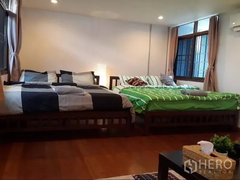 ทาวน์เฮาส์ ให้เช่าในKhlong Toei, Bangkok - ห้องนอนกว้าง มีเตียงคู่สองเตียง พื้นไม้ หน้าต่างบานใหญ่พร้อมผ้าม่าน แสงไฟนุ่มนวล