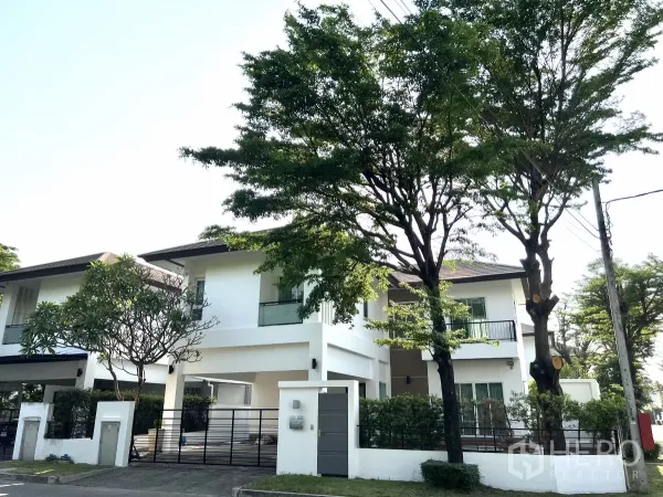 Detached House for rent or sale in Saphan Sung, Bangkok - Two-storey modern white detached house with balcony, trees and gated fence on a quiet street in Saphan Sung.