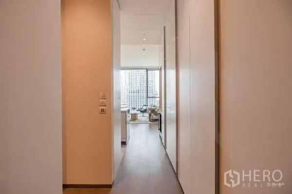 Condominium for rent - Hallway leading to living area with floor-to-ceiling windows and city view.