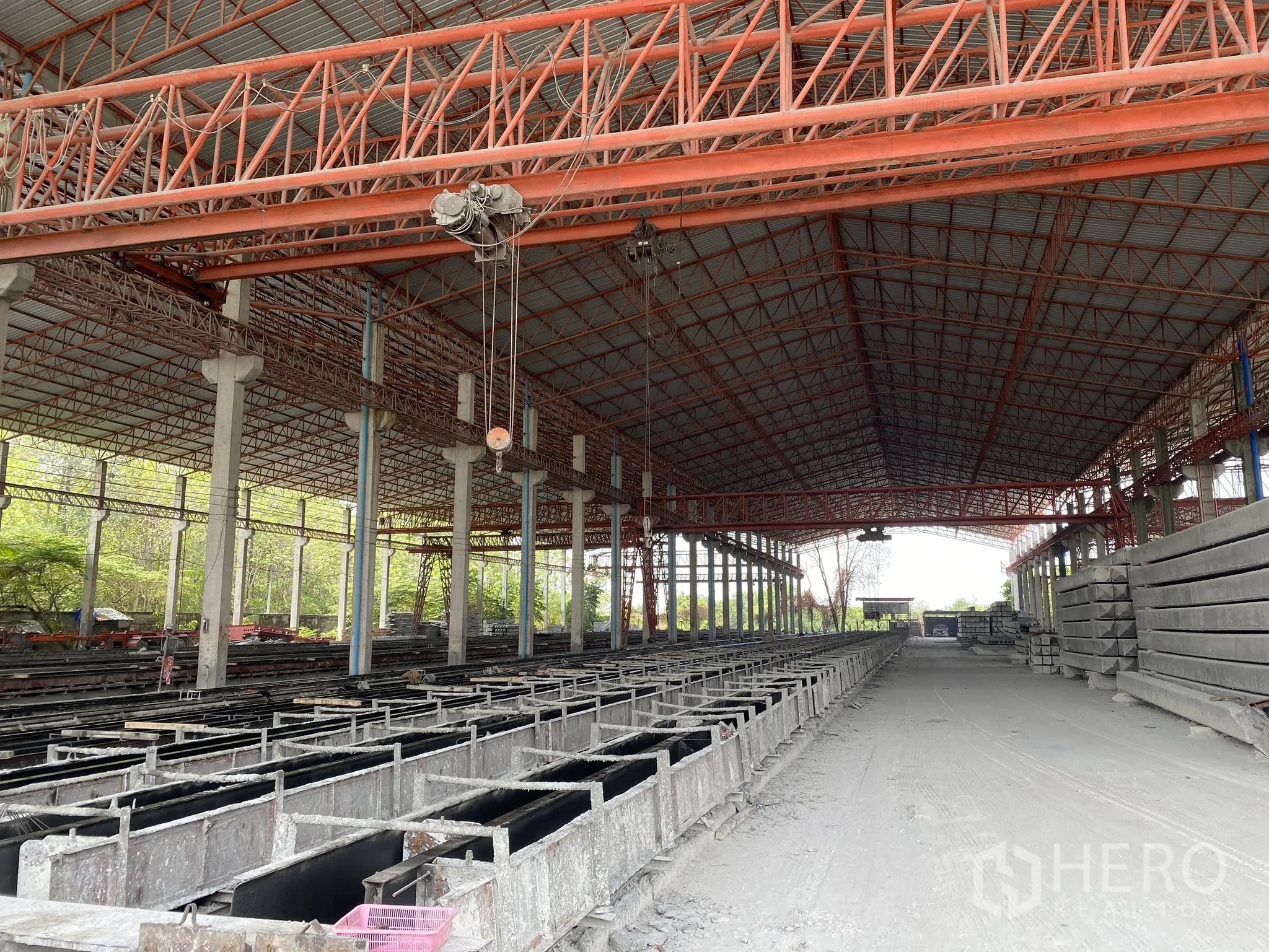 Factory for sale in Mueang Chon Buri, Chon Buri - Long rows of concrete casting beds under a high truss roof with hoist.