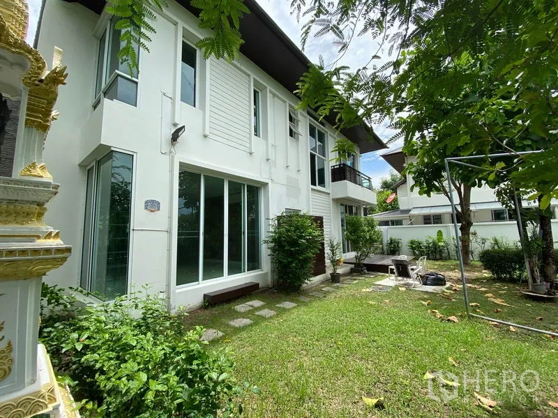 Detached House for rent in Prawet, Bangkok - Side facade with large sliding glass doors opening to a lawn and small patio garden.