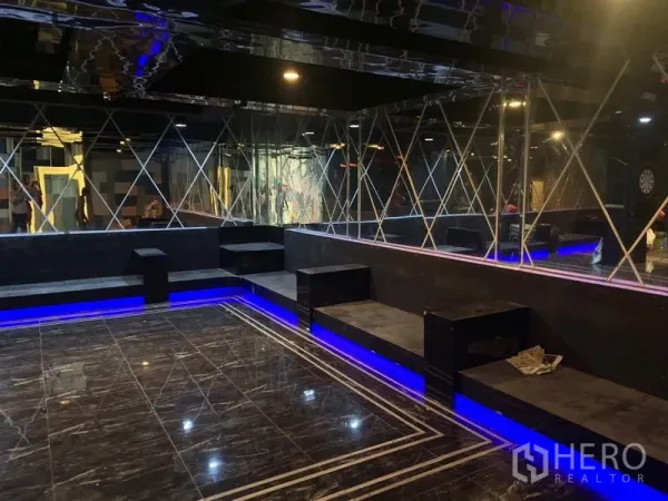 店屋 出租在Watthana, Bangkok - 镜面墙休闲区，黑色大理石地面、内置座位与蓝色氛围灯。