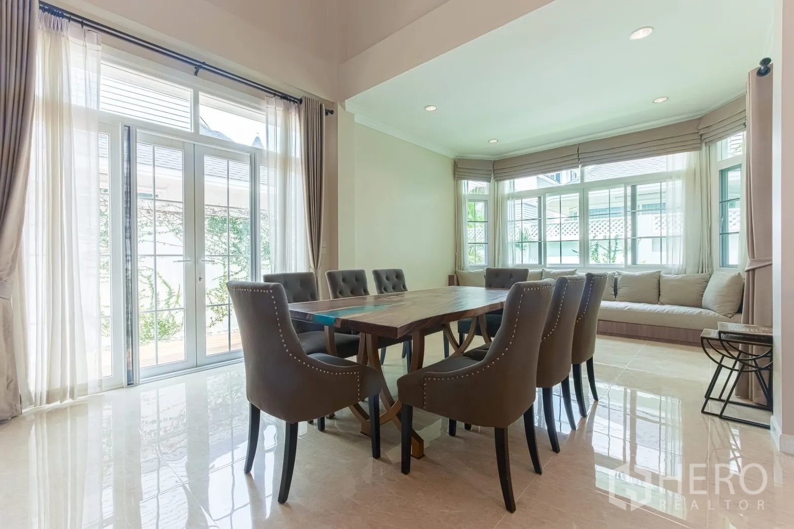 Detached House for rent in Bang Na, Bangkok - Dining space with glass doors to terrace and a long bay-window bench.