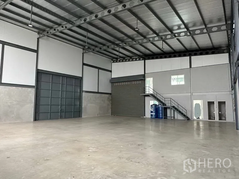 คลังสินค้า ให้เช่าในSamut Prakan - มุมมองภายในโชว์ประตูบานเลื่อนขนาดใหญ่ ประตูม้วน และออฟฟิศชั้นลอยพร้อมบันได