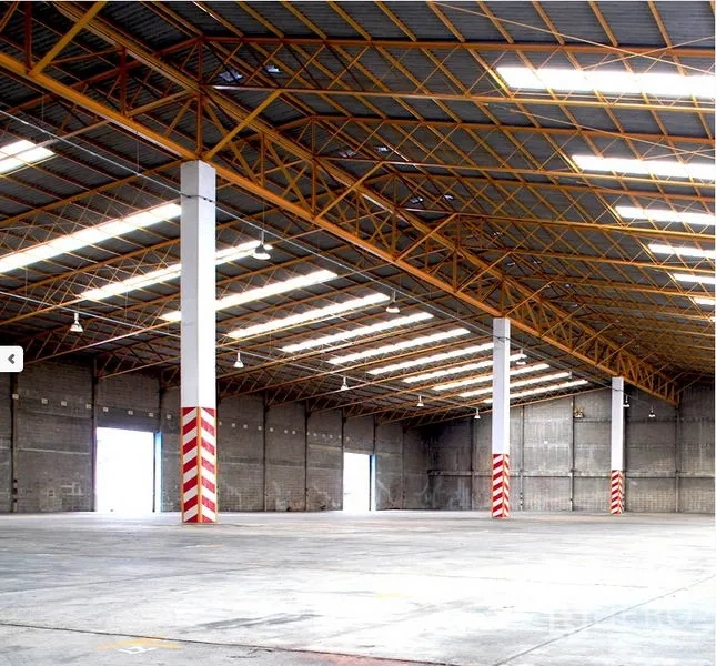 工厂 出租在Samut Prakan - 仓库内部：高挑钢桁架屋顶，天窗采光，混凝土地面与多处装卸口。