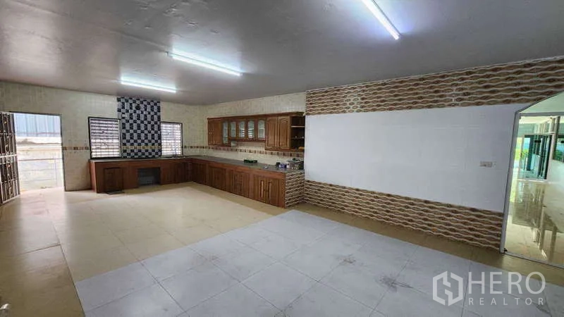 Factory for rent in Pak Kret, Nonthaburi - Large staff kitchen with built-in wooden cabinets, tiled walls and windows