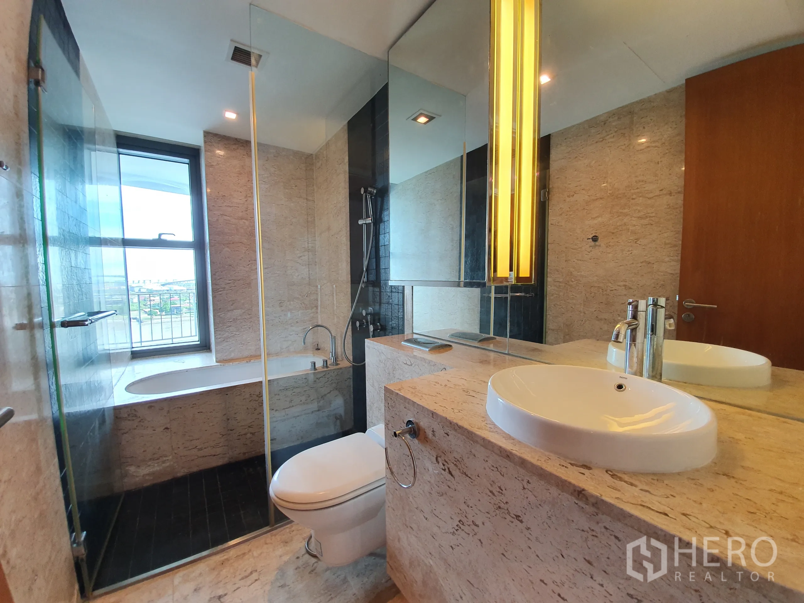 Condominium for rent or sale in Yan Nawa, Bangkok - Modern bathroom with window‑side bathtub, glass shower, and marble vanity.
