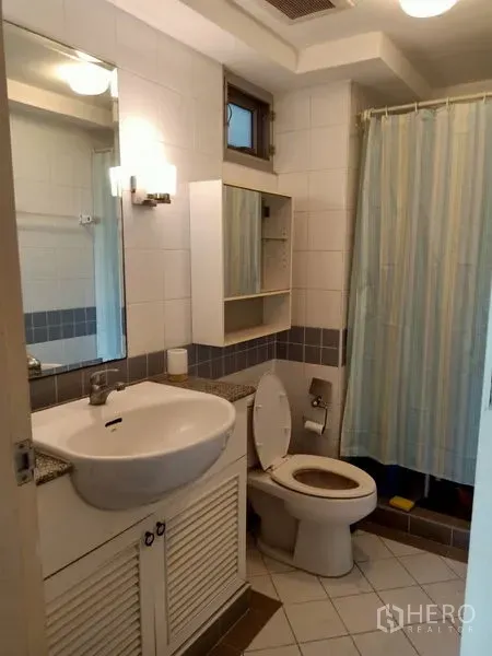 คอนโด ให้เช่าในKhlong Toei, Bangkok - ห้องน้ำกระเบื้องสีขาวพร้อมอ่างล้างหน้า ตู้กระจก สุขภัณฑ์ และโซนอาบน้ำม่านกั้น