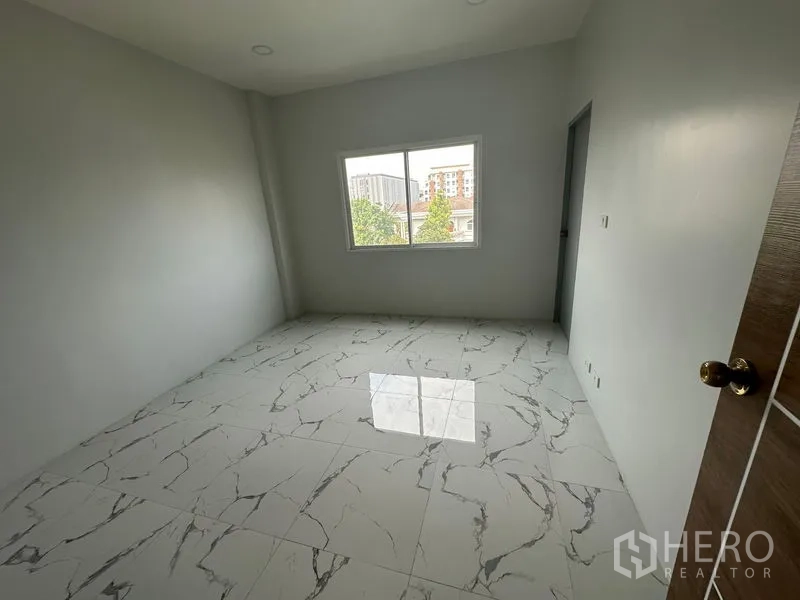 Home Office for rent or sale - Upper-level bedroom with window overlooking nearby buildings and trees.