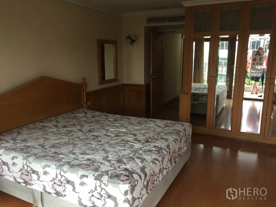 คอนโด ให้เช่าในKhlong Toei, Bangkok - ห้องนอนหลักพื้นไม้พร้อมตู้เสื้อผ้าบานกระจกและทางออกสู่ระเบียง