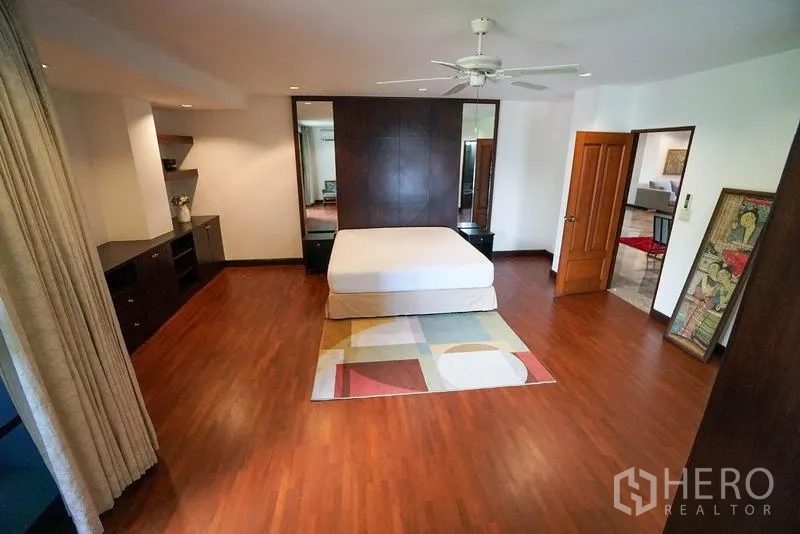 อพาร์ทเมนท์ ให้เช่าในWatthana, Bangkok - มุมมองห้องนอนใหญ่ เตียงกลางห้อง ตู้บิลต์อิน และพรมลาย