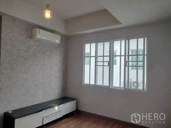 ทาวน์เฮาส์ ให้เช่าในBueng Kum, Bangkok - ห้องอเนกประสงค์สว่าง มีแอร์ ผนังลายหิน และตู้วางทีวีใต้หน้าต่าง