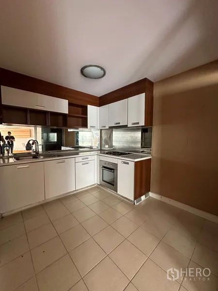 公寓 出租或出售在Yan Nawa, Bangkok - L型厨房，白色橱柜、嵌入式烤箱与瓷砖地面。