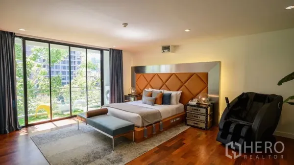 Condominium for rent in Pathum Wan, Bangkok - Master bedroom with floor-to-ceiling windows, balcony, and green city views.