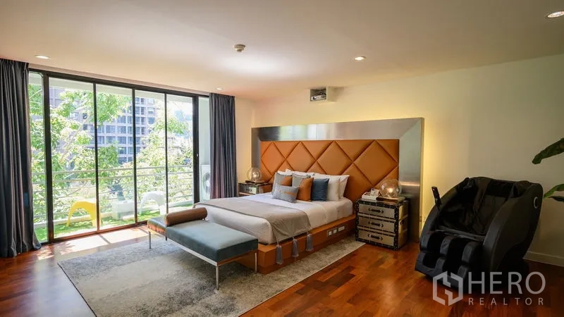 Condominium for rent in Pathum Wan, Bangkok - Master bedroom with floor-to-ceiling windows, balcony, and green city views.