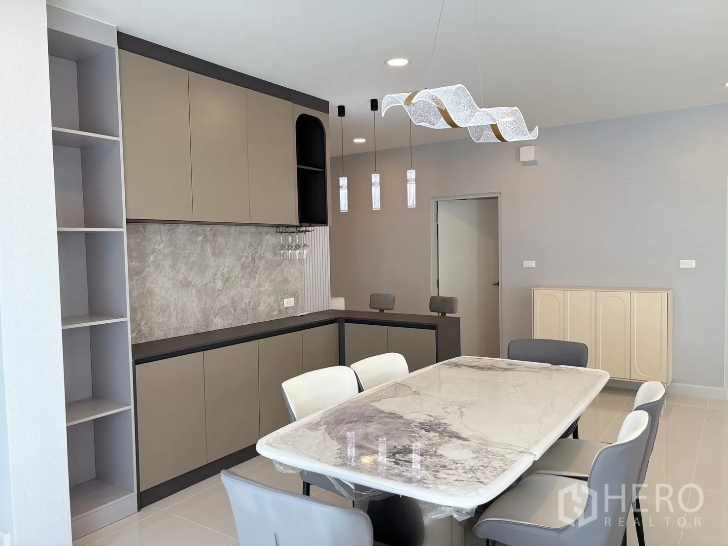 Detached House for rent in Bang Phli, Samut Prakan - Open dining room with full-height cabinetry, stone backsplash and designer chandelier.