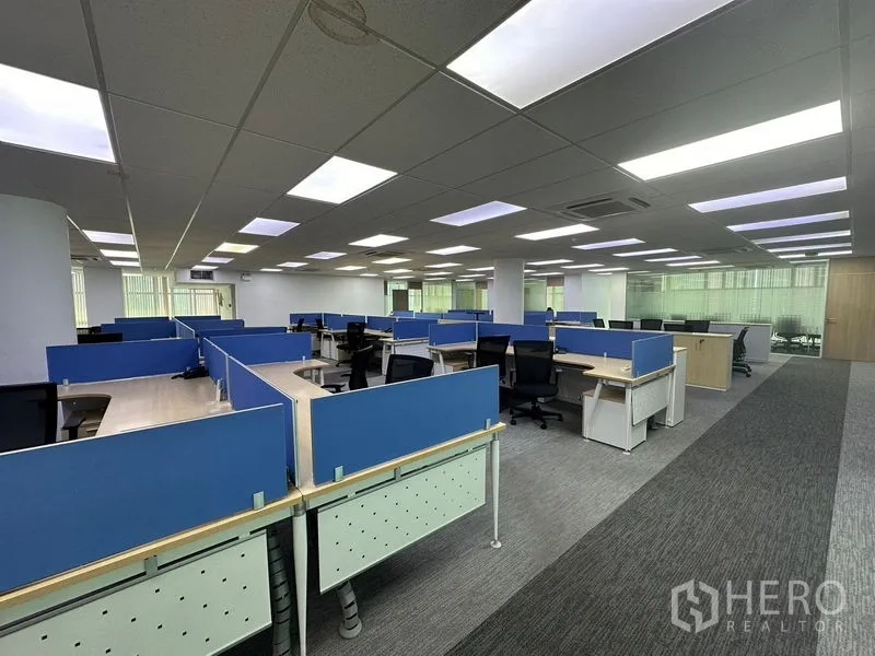 Office Space for rent - Open-plan office area with blue partitioned cubicles, task chairs and grid ceiling lights.