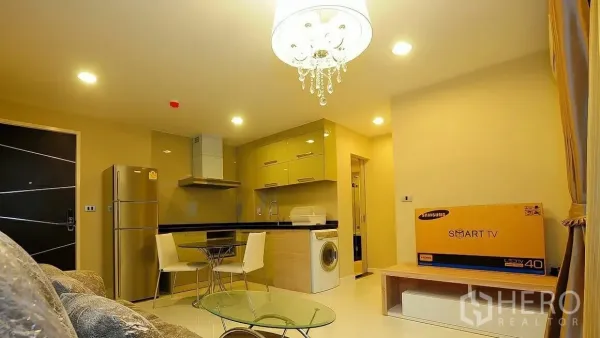 คอนโด ขายในKhlong Toei, Bangkok - ห้องนั่งเล่นและครัวแบบเปิดพร้อมโคมระย้า ตู้เย็น เครื่องซักผ้า และกล่องทีวี ในคอนโดสุขุมวิท