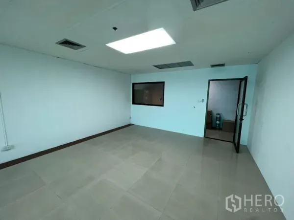 办公空间 出租在Huai Khwang, Bangkok - 空置办公室，瓷砖地面、吊顶灯和空调出风口，带内置玻璃窗与玻璃门，位于曼谷辉煌区。