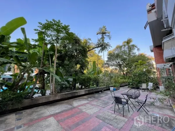 ทาวน์เฮาส์ ให้เช่าในKhlong Toei, Bangkok - ลานปูพื้นกระเบื้องกว้างพร้อมชุดโต๊ะเก้าอี้ กลางสวนเขตร้อนร่มรื่น