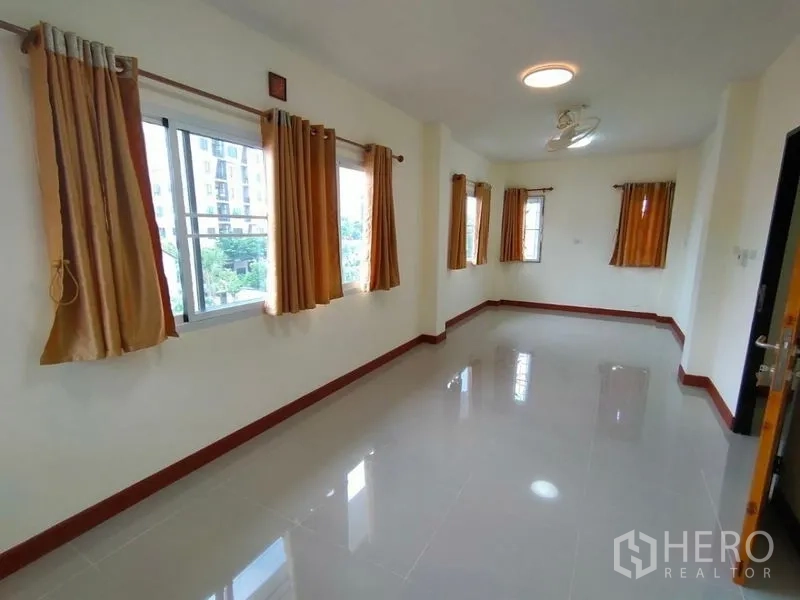 บ้าน ให้เช่าในKhlong Toei, Bangkok - ห้องโล่งสว่าง พื้นกระเบื้องเงา มีหน้าต่างหลายบานพร้อมผ้าม่านสีมัสตาร์ด