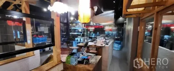 店屋 出租在Khlong Toei, Bangkok - 前台与服务区，木质框架、玻璃隔断与展示架。