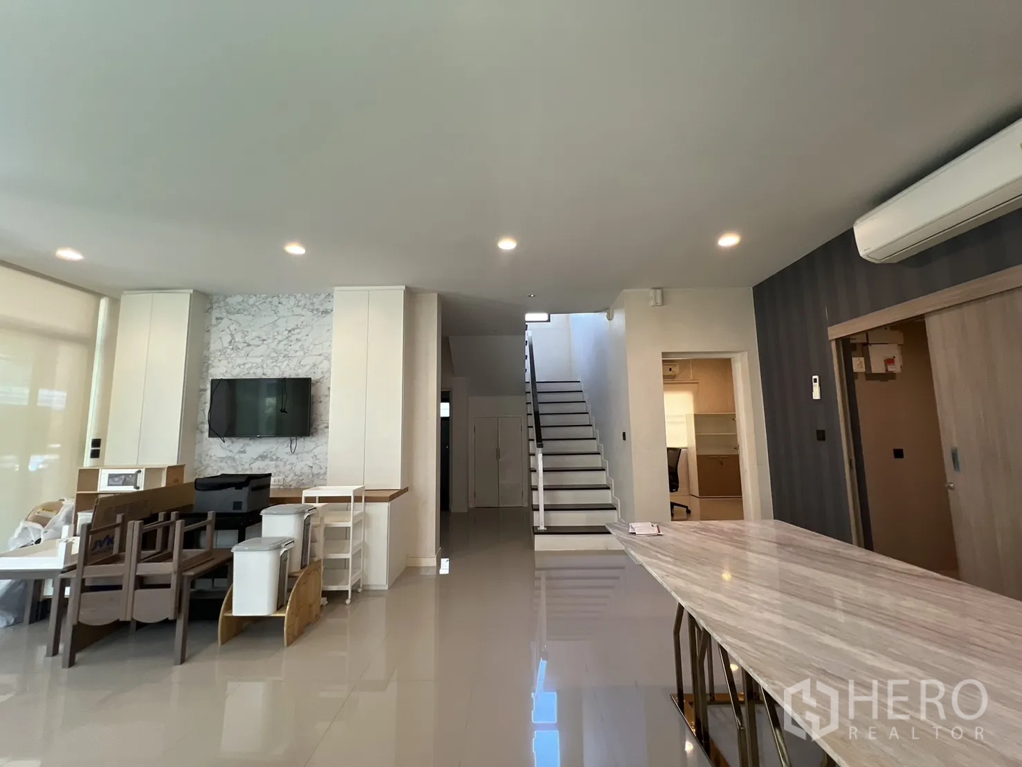 独立式住宅 出售在Bang Kapi, Bangkok - 客餐一体区，仿大理石背景墙、楼梯与长岛台。