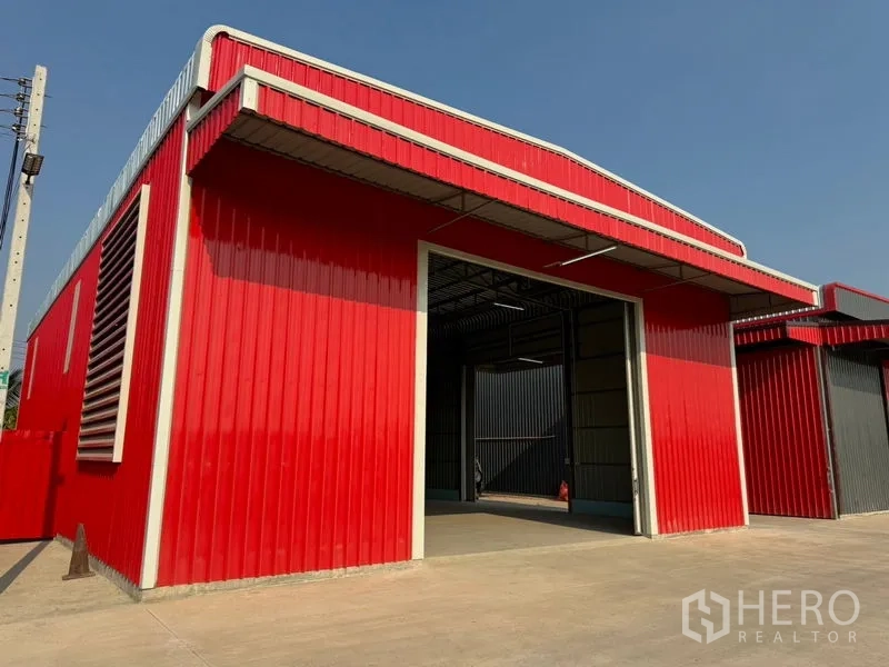 货栈 出租在Lam Luk Ka, Pathum Thani - 红色仓库正面，高挑出入口与混凝土装卸场地。