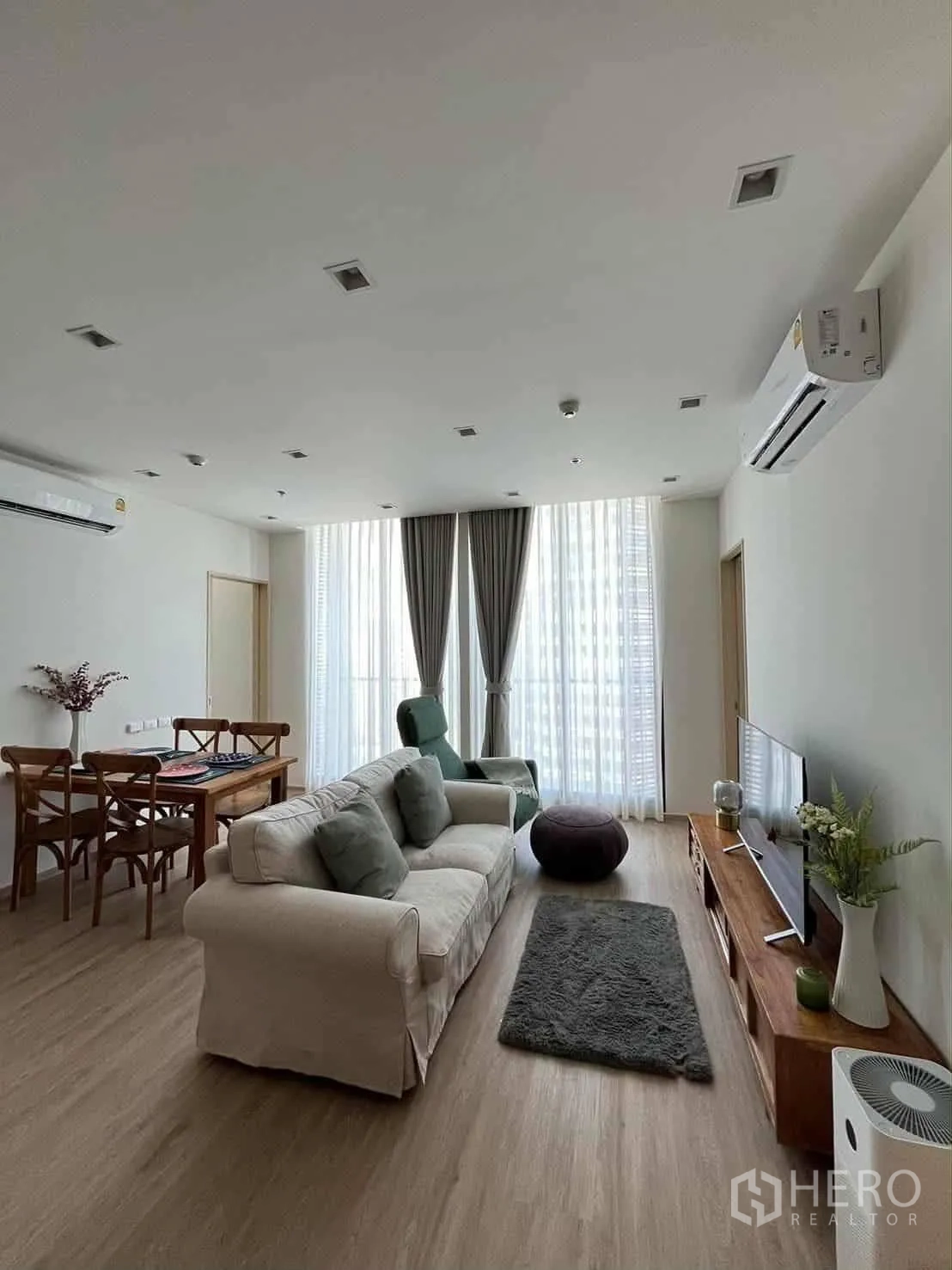 公寓 for rent in Watthana, Bangkok - 开放式客厅，沙发、电视柜、餐桌以及高窗帘大窗。