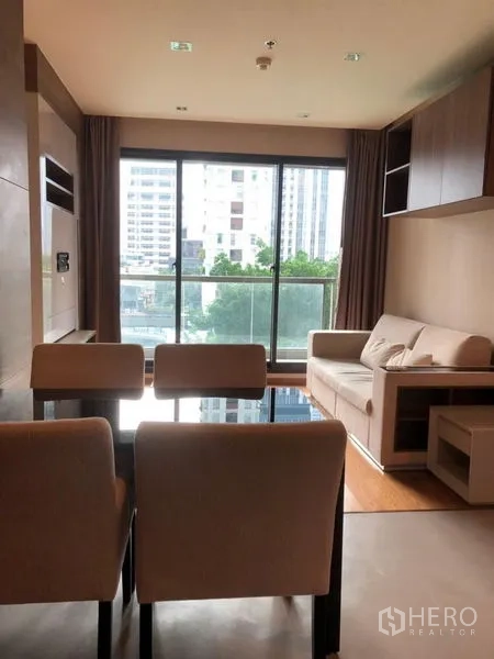 公寓 出售在Bang Rak, Bangkok - 采光充足的客餐厅，落地窗与沙发餐椅，可欣赏城市景观。