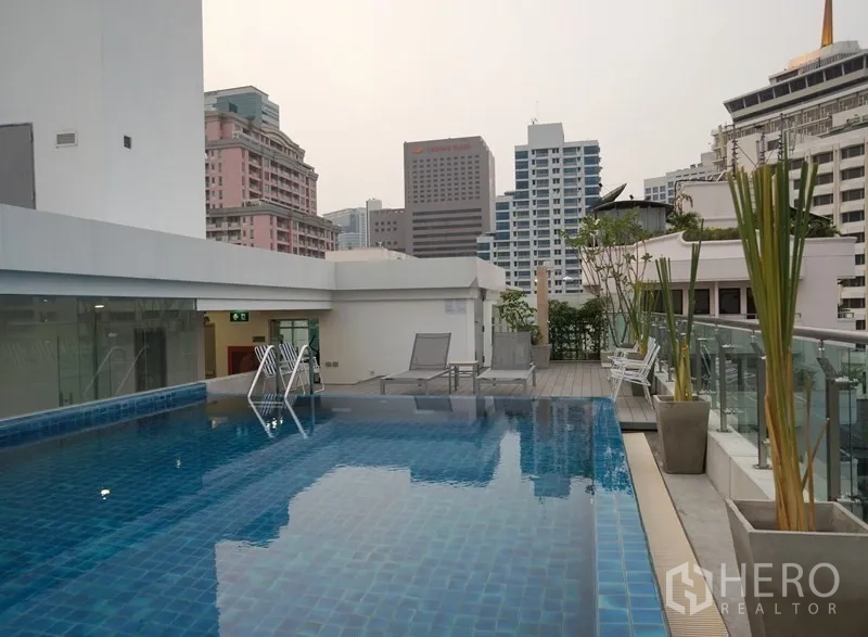 公寓 出租或出售在Bang Rak, Bangkok - 屋顶游泳池，玻璃护栏与城市天际线景观及躺椅。
