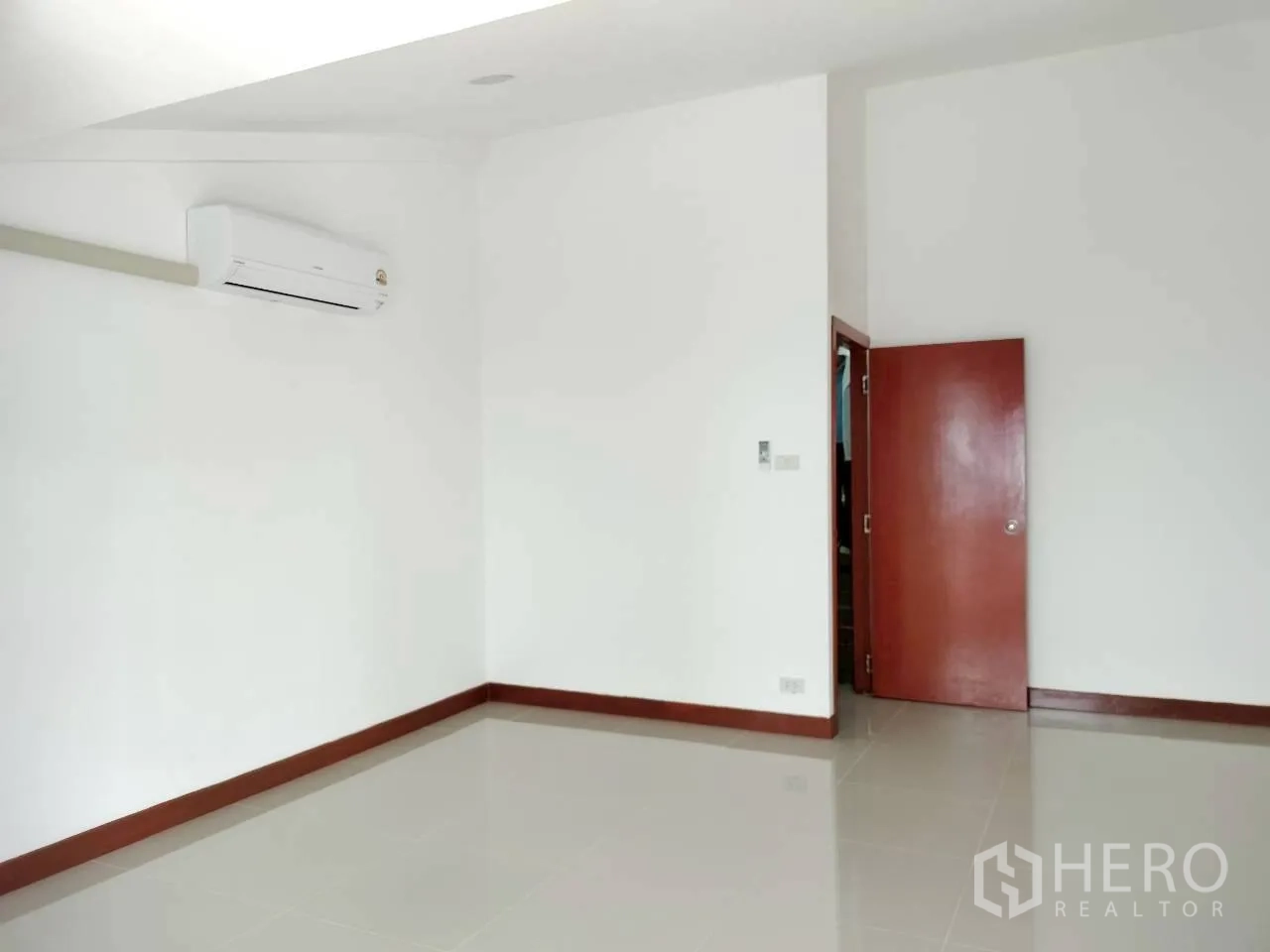 Home Office for rent in Watthana, Bangkok - Bright white room with glossy tiles and wall-mounted air conditioner.