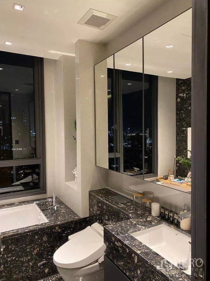 公寓 出租或出售在Khlong Toei, Bangkok - 浴室带大镜与石面台盆、坐便器，可见城市夜景。
