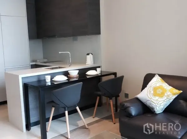 公寓 出租在Khlong Toei, Bangkok - 开放式厨房配早餐吧台与两把椅子，连接客厅