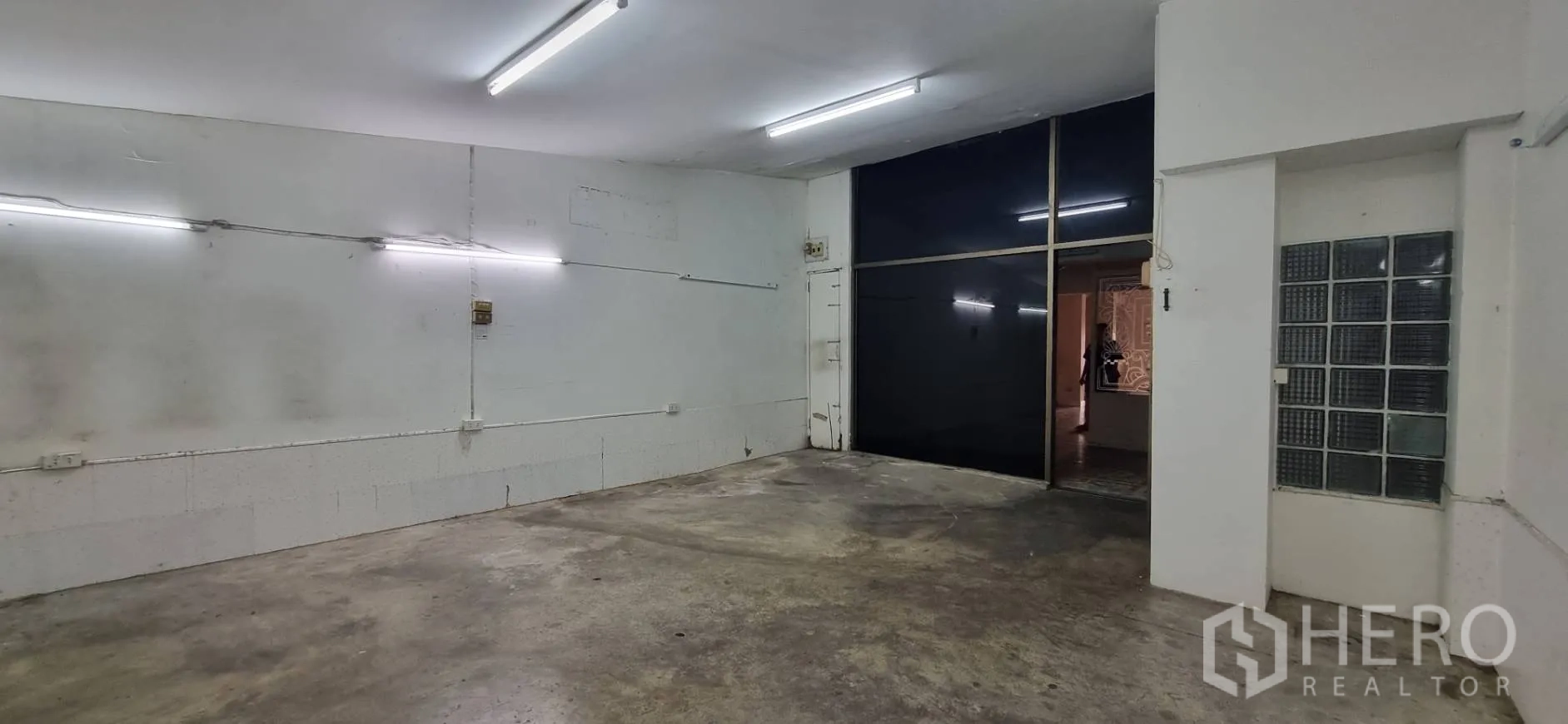 店屋 出租或出售在Bangkok - 储物间朝向深色玻璃隔断与玻璃砖墙的视角。