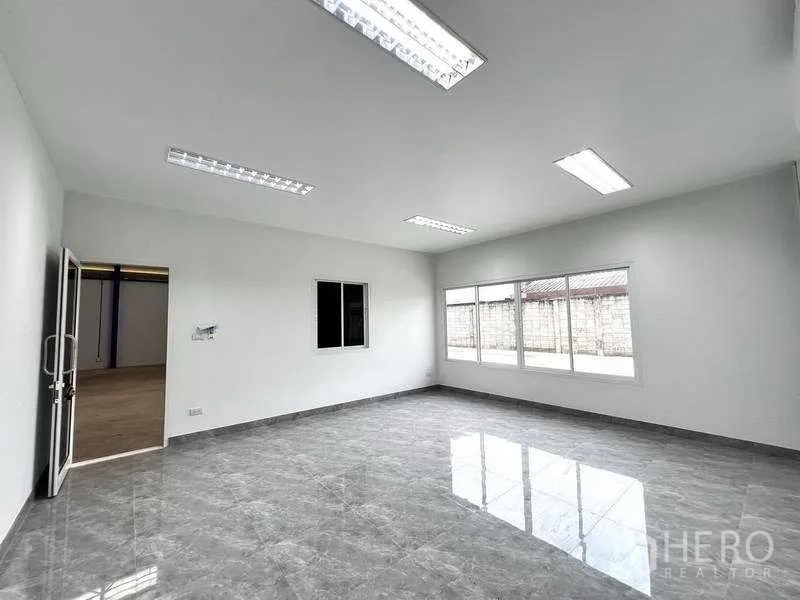 Warehouse for rent in Lat Lum Kaeo, Pathum Thani - Bright office room with large windows and glossy gray tile flooring.