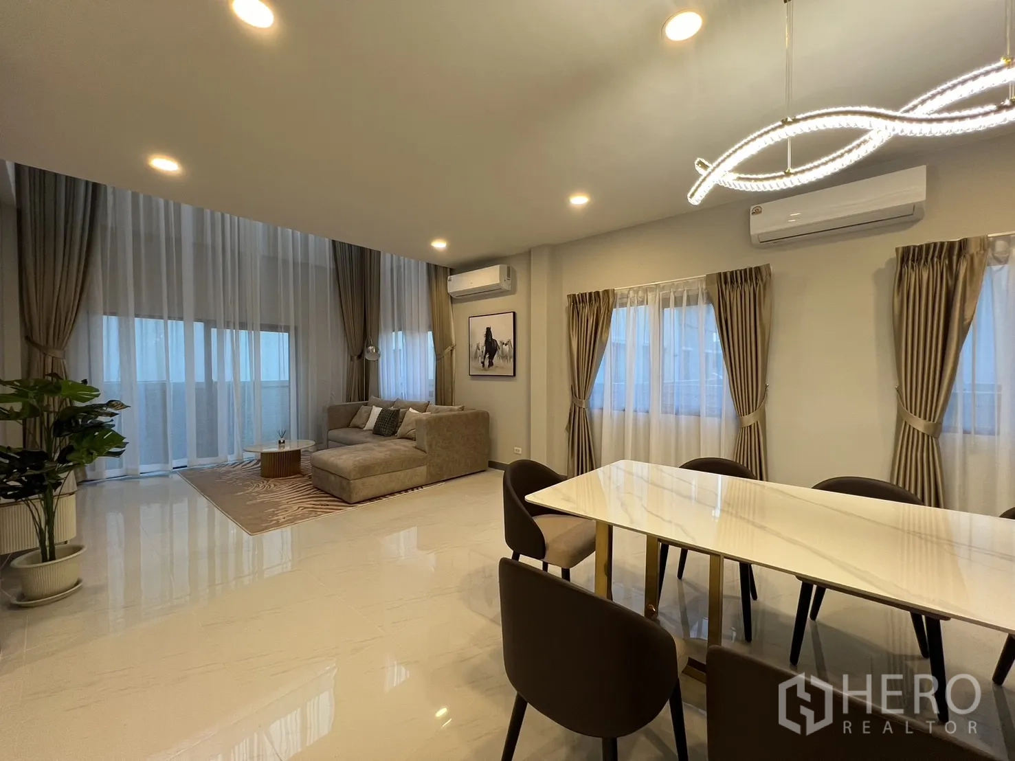Detached House for rent or sale in Bang Phli, Samut Prakan - Open-plan living and dining space with floor-to-ceiling curtains and warm lighting.