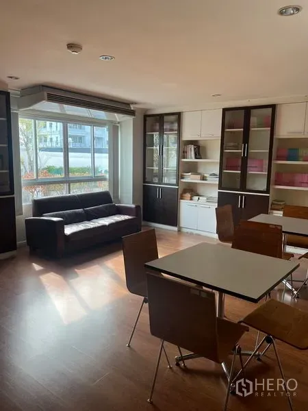 คอนโด ขายในWatthana, Bangkok - ห้องพักส่วนกลางรับแสงธรรมชาติ มีโซฟา ชั้นหนังสือ และโต๊ะอาหาร