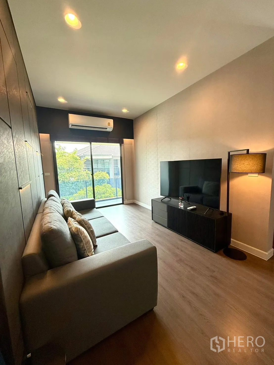 Detached House for rent in Bang Kapi, Bangkok - Upper family room with sofa, TV console and balcony access through sliding doors.